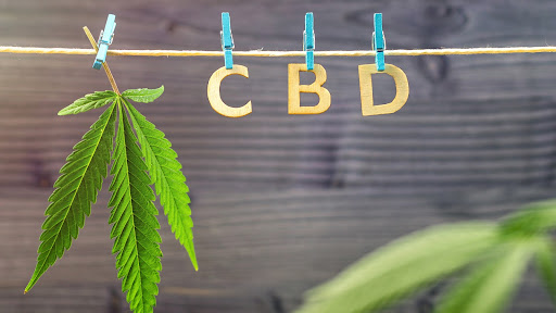 A cannabis leaf and the letters C, B, D pegged on a rope