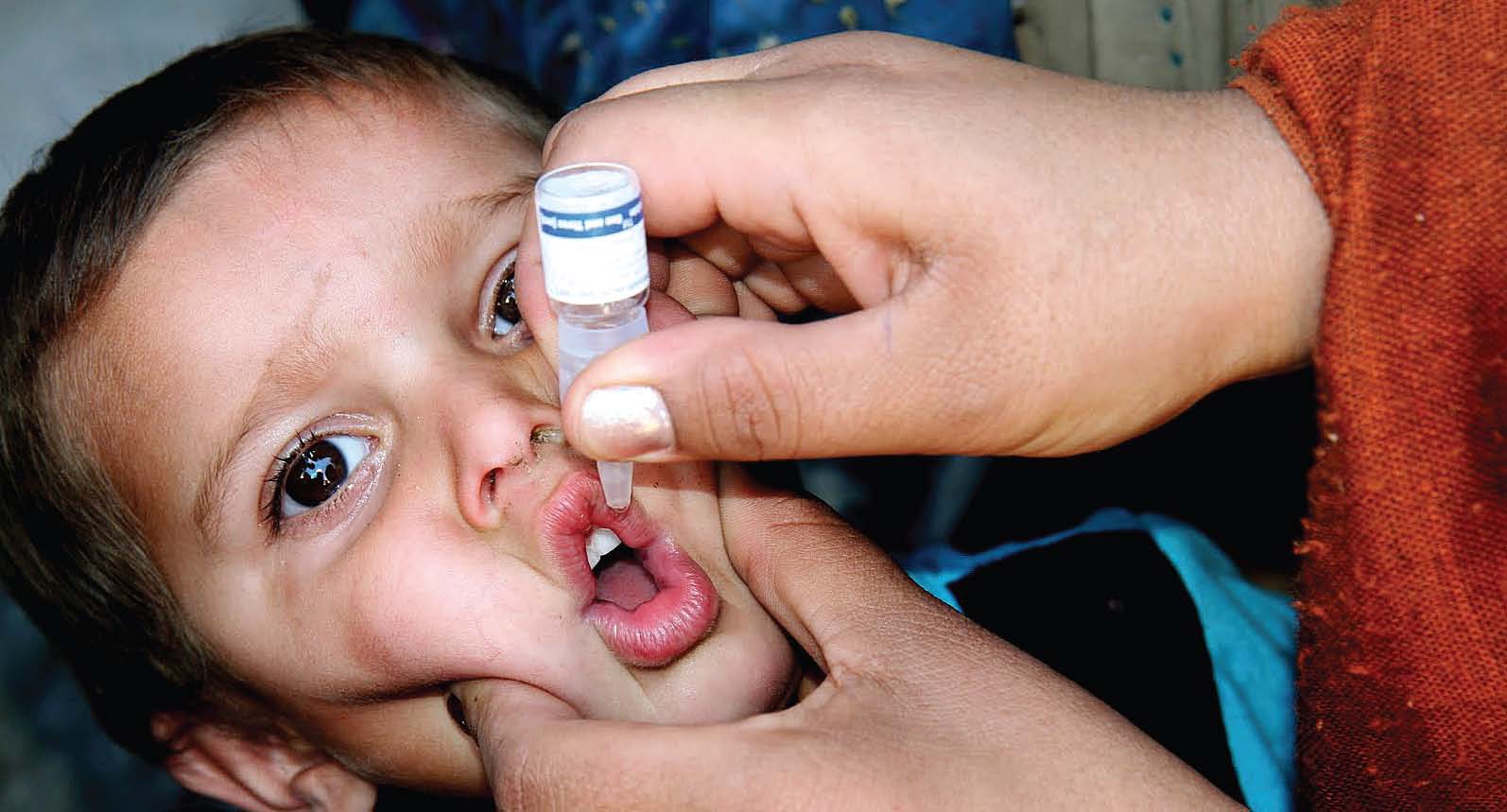A little boy being given the polio vaccine through his mouth