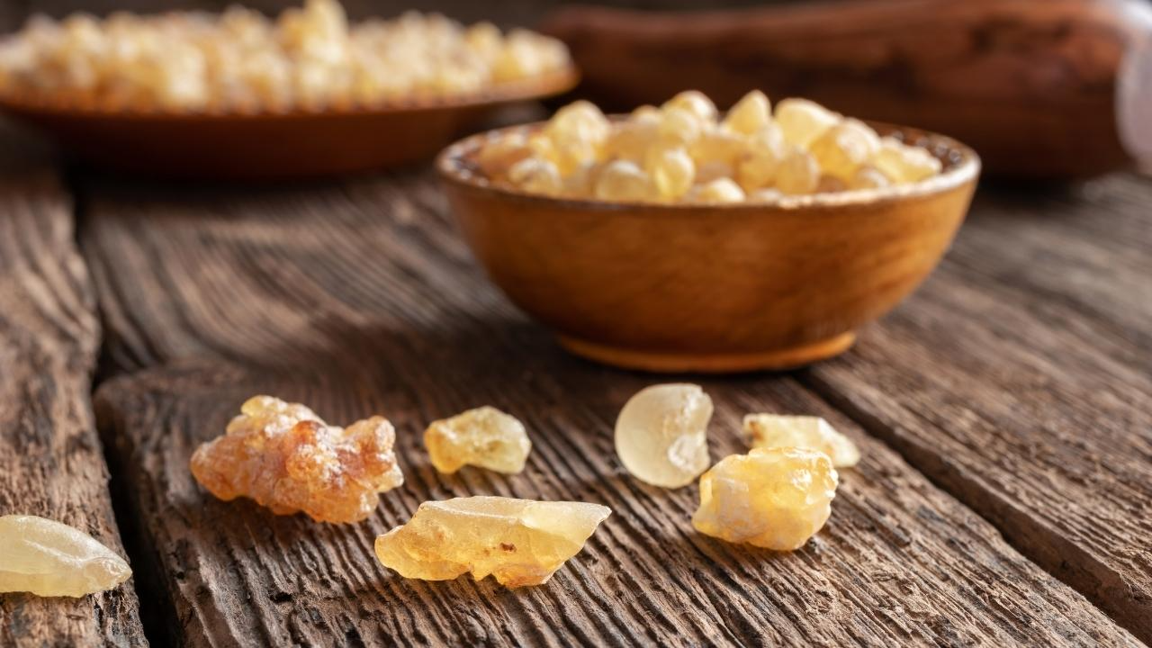 Frankincense seeds on a wooden platform with some in wooden platters in the background