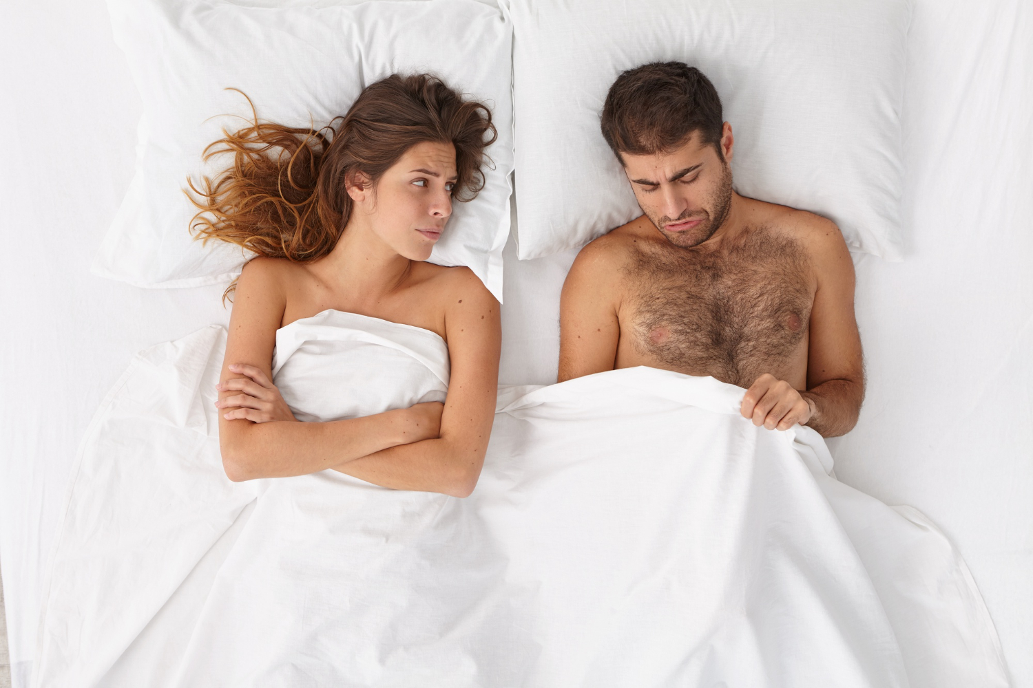 A couple on the bed while the man has an erectile dysfunction problem