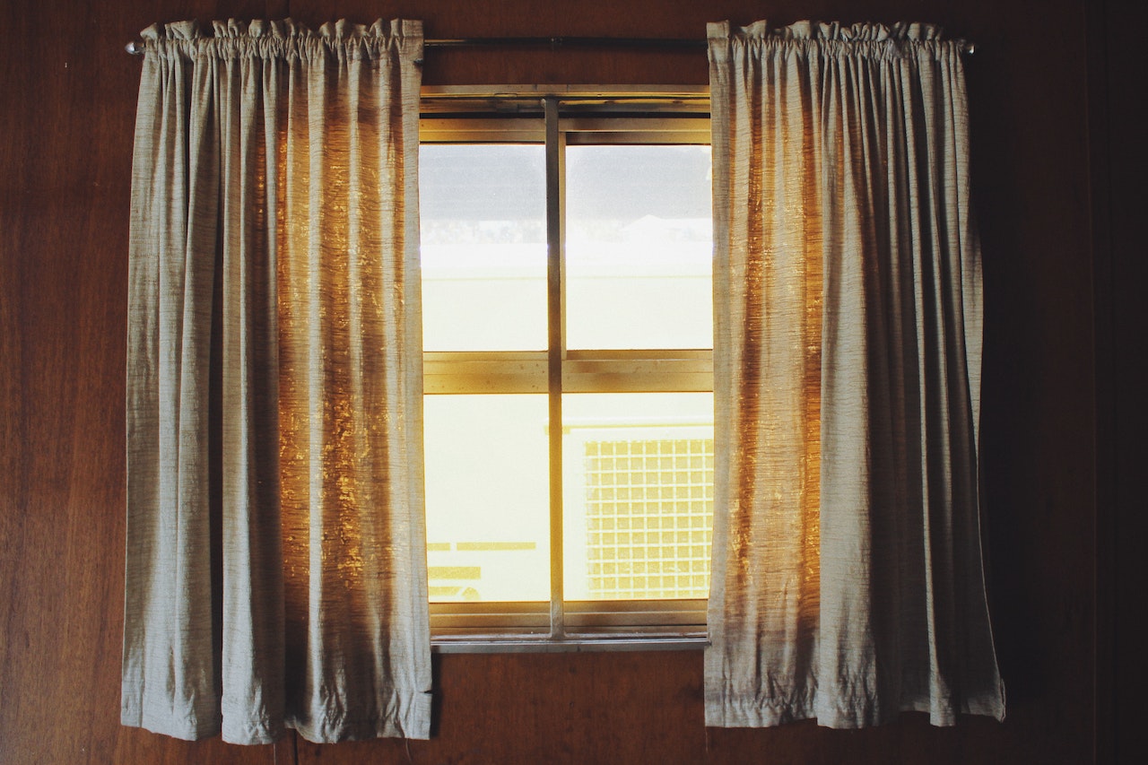 Two White Rod Pocket Curtains At The Window